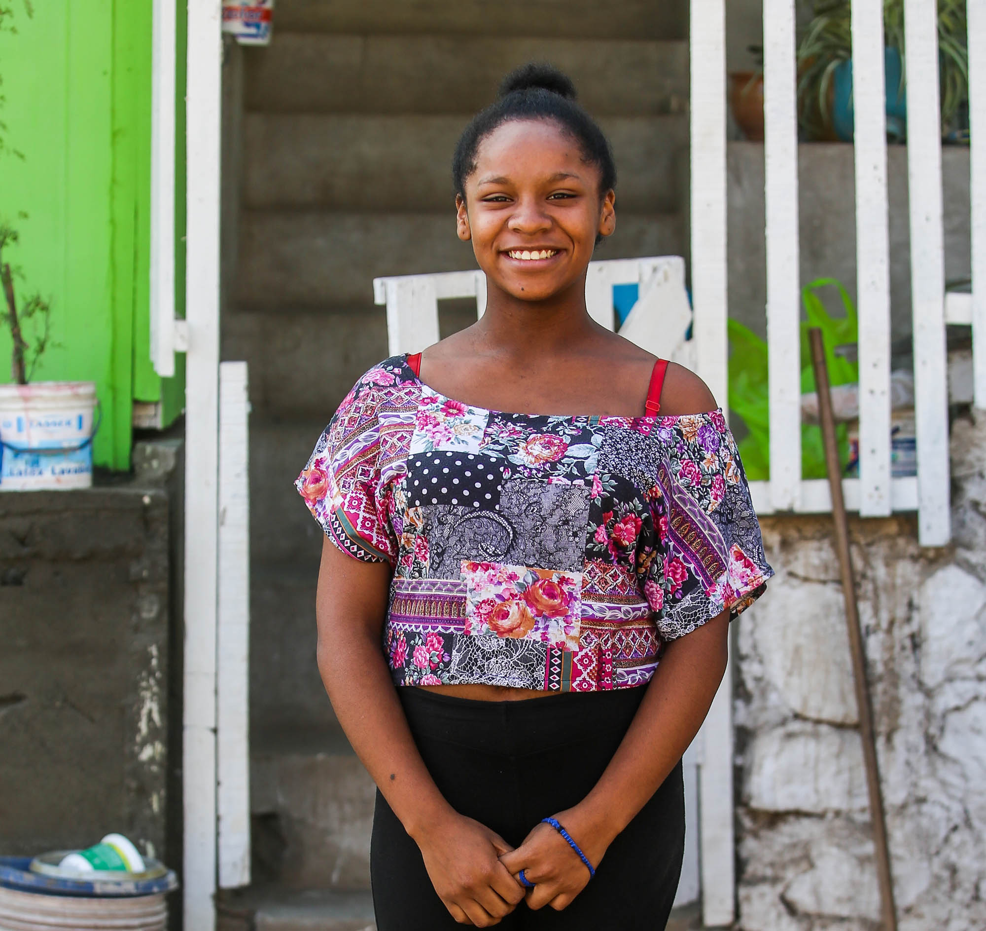 Afro-Peruvian girl standing in front of her house smiling at the camera