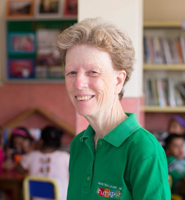 White woman smiling in green shirt