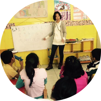 Japanese woman teaching children on whiteboard